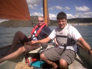 Two men sailing underneath Constitution Hill (Aberystwyth)